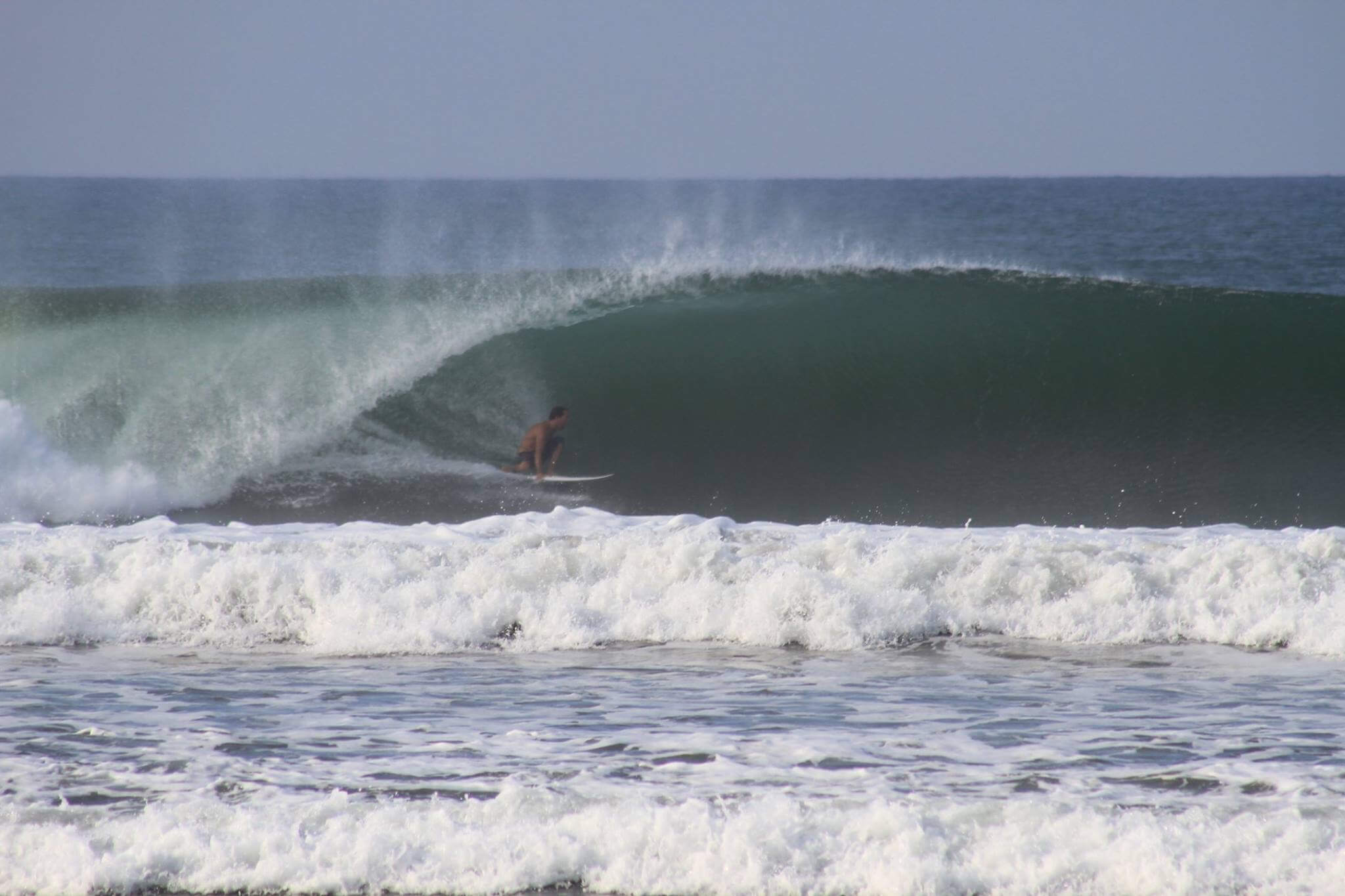 Advanced surfer riding a heavy barrel at Playa Dominical