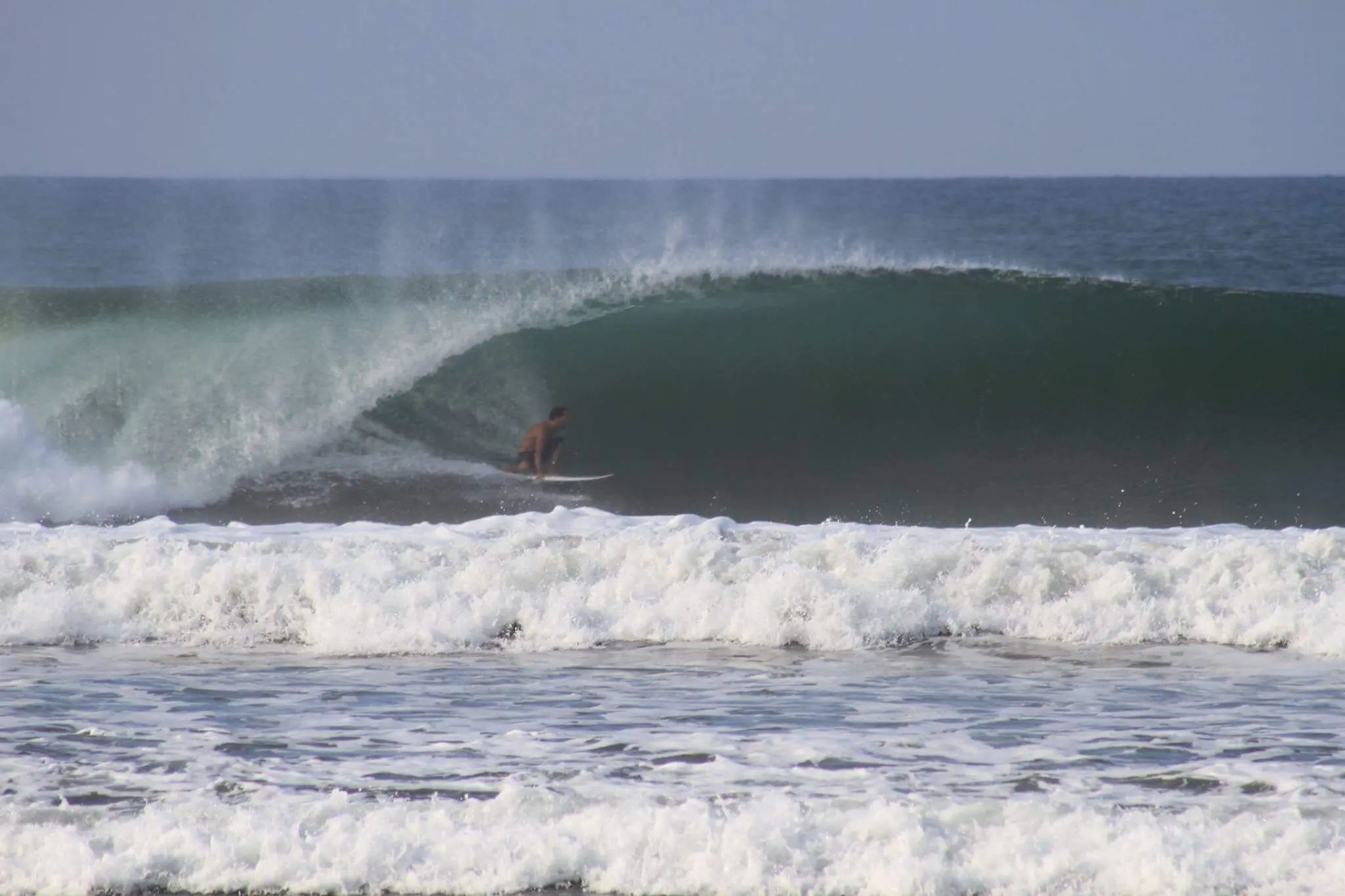 Advanced surfer riding a heavy barrel at Playa Dominical