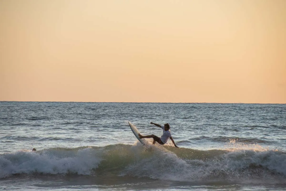 Surfer riding a sunset wave at Playa Guiones Nosara Costa Rica